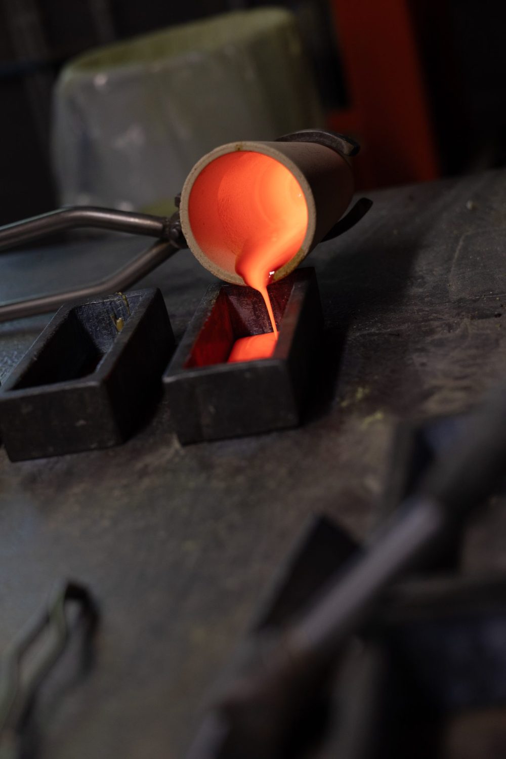 Molten metal poured from a crucible into an ingot mould during fire assay